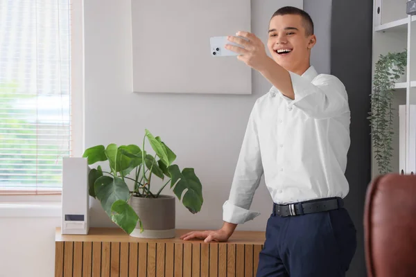 オフィスで携帯電話のビデオチャットを持つ若い男 — ストック写真