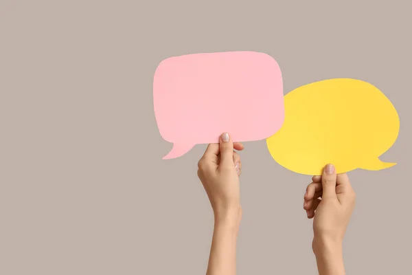 stock image Female hands with speech bubbles on grey background