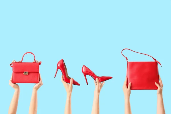 Manos Femeninas Sosteniendo Elegantes Bolsos Zapatos Mujer Sobre Fondo Azul —  Fotos de Stock
