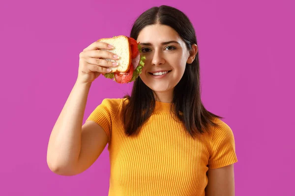 Mujer Joven Con Sabroso Sándwich Sobre Fondo Púrpura —  Fotos de Stock