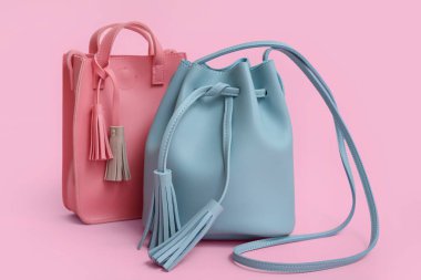 Pembe arka planda farklı tarz çantalar.