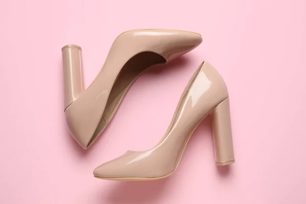 Stylish beige high heels on pink background