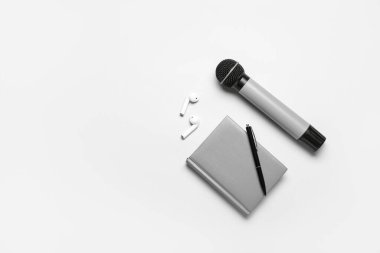 Kalemi, mikrofonu ve kulaklığı olan bir defter.