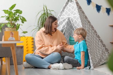 Dadı evde küçük çocukla oynuyor.