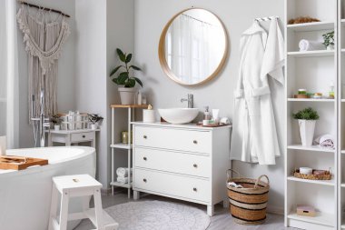 Lavabosu, aynası ve küveti olan bir banyo.