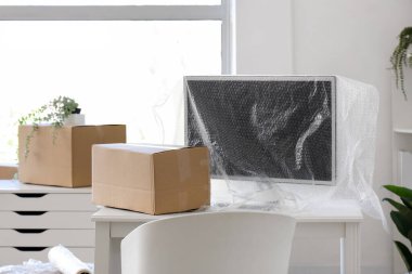 Karton kutularla aydınlık ofisin içi ve taşınma gününde gerilmiş film.