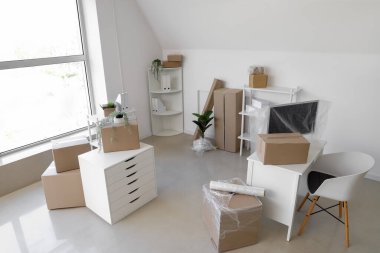 Karton kutularla aydınlık ofisin içi ve taşınma gününde gerilmiş film.