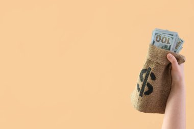 Bej arka planda bir çanta dolusu parası olan kadın.