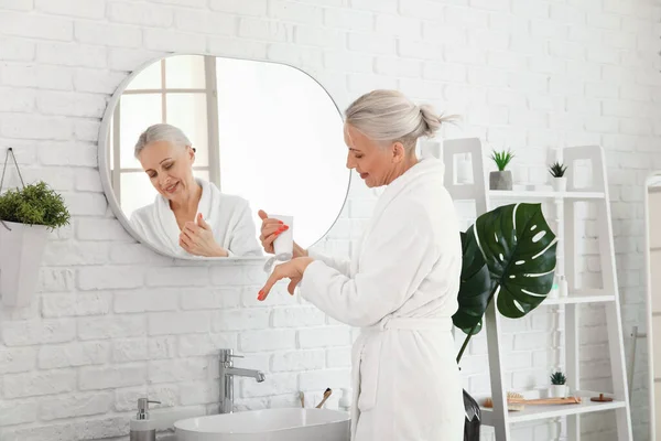 Mature Woman Applying Hand Cream Bathroom — Stock Photo, Image