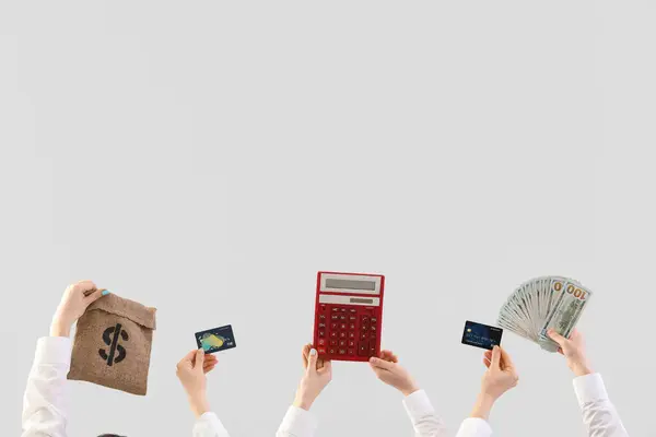 Women with money, bag, calculator and credit cards on light background