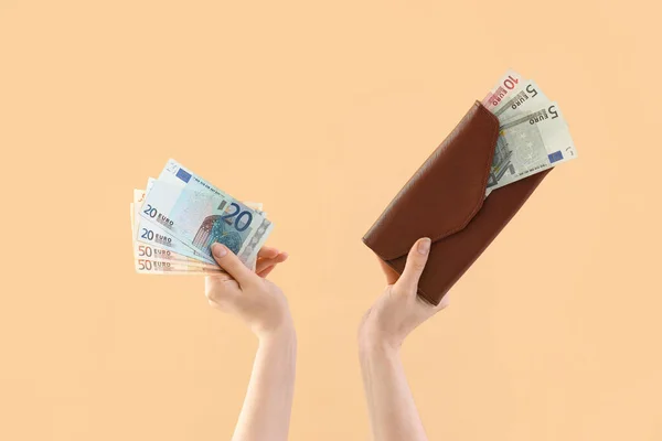 Woman with money and wallet on beige background