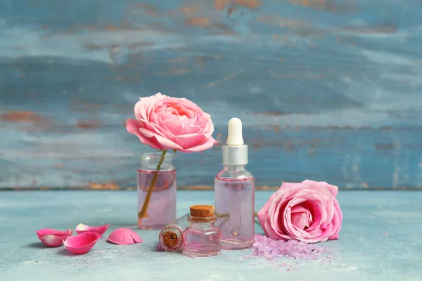 Bottles Cosmetic Oil Rose Extract Flowers Blue Table — Stock Photo, Image