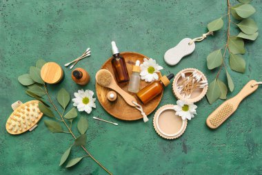 Renkli arka planda kozmetik ürünleri, banyo malzemeleri ve çiçeklerle kompozisyon