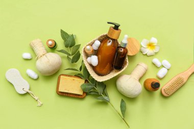 Kozmetik ürünleri, spa aksesuarları ve yeşil arka planda okaliptüs dalıyla kompozisyon