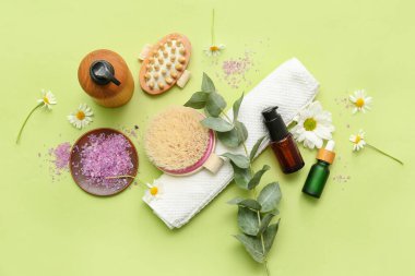Banyo malzemeleri, kozmetik ürünleri ve yeşil arka planda çiçekler içeren kompozisyon