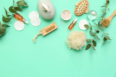 Farklı banyo malzemelerine, kozmetik ürünlere ve renk arkaplanına okaliptüs dallarına sahip kompozisyon