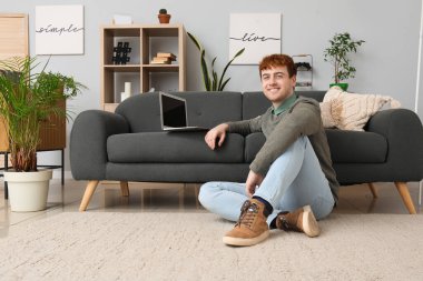 Evde dizüstü bilgisayarla çalışan serbest çalışan erkek.