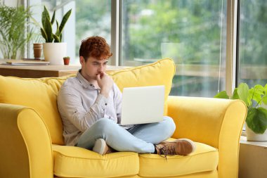 Erkek freelancer evde kanepede dizüstü bilgisayar ile çalışma