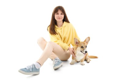 Beyaz arka planda oturan sevimli Corgi köpeği olan güzel genç bir kadın.