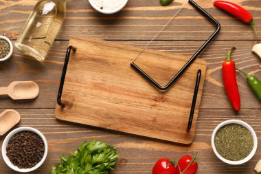 Tahta kesme tahtasıyla, otlarla, sebzelerle ve baharatlarla ahşap arka planda kompozisyon