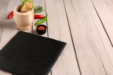 Tahta tahtayla kompozisyon ve hafif ahşap arka planda taze baharatlar.