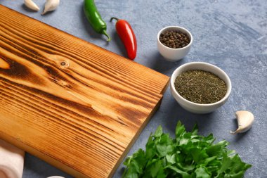 Ahşap mutfak tahtasıyla kompozisyon ve renk arkaplanda farklı baharatlar, yakın plan