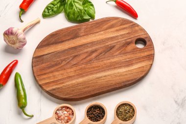 Ahşap kesim tahtasıyla kompozisyon ve arka planda taze baharatlar