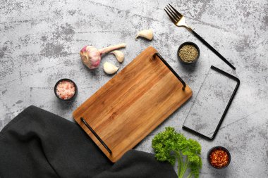 Ahşap mutfak tahtasıyla kompozisyon ve grunge arkaplanda farklı baharatlar