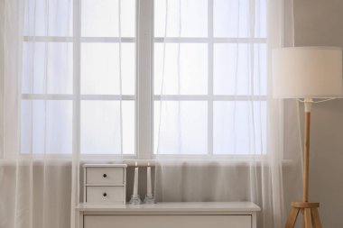 Odadaki pencerenin yanındaki çekmecelerde mum yakmak