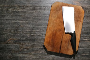 Ahşap zeminde yeni kesim tahtası ve et satırı