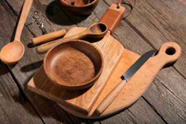 Farklı kesme tahtaları, kase, kaşıklar ve tahta arka planda bıçak.