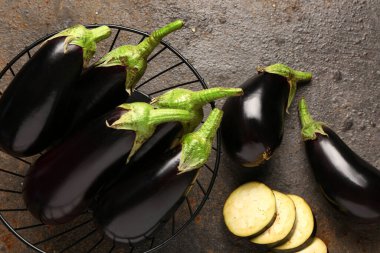 Kahverengi arka planda taze patlıcan sepeti.
