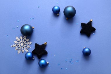 Mavi arka planda Noel topları ve kar tanesinden yapılmış çerçeve