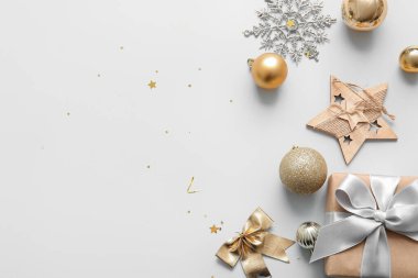 Noel baloları, kar taneleri ve beyaz arka planda hediye kutusu.