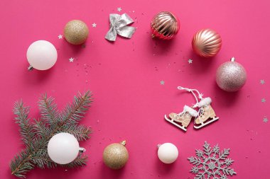 Topları, kar taneleri ve pembe arka planı olan Noel ağacı dallarından yapılmış bir çerçeve.