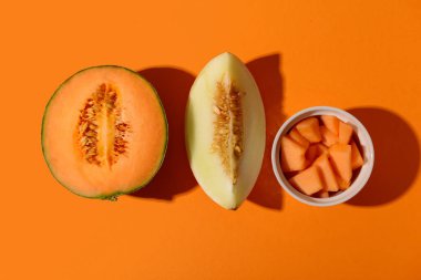 Tatlı karpuzlar ve turuncu arka planda parçalar.