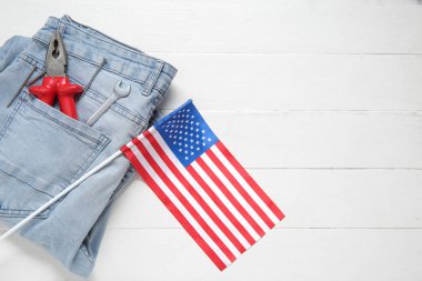 Aletli kotlar ve beyaz ahşap arka planda Amerikan bayrağı. İşçi Bayramı kutlamaları