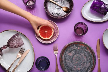 Greyfurtlu kadın eli ve mor arka planda güzel bir masa.