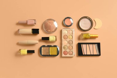 Turuncu arka planda farklı dekoratif kozmetik ürünler