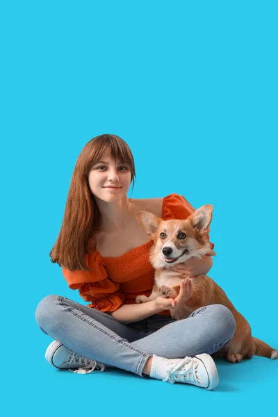 Όμορφη Νεαρή Γυναίκα Κάθεται Χαριτωμένο Corgi Σκυλί Μπλε Φόντο — Φωτογραφία Αρχείου