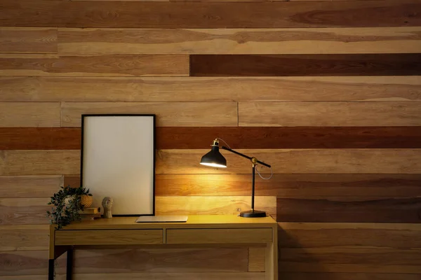 Desk Glowing Lamp Modern Laptop Blank Frame Houseplant Wooden Wall — Stock Photo, Image