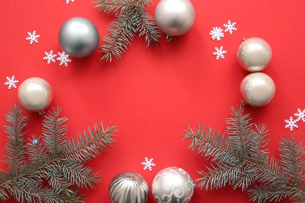 Rahmen Aus Weihnachtsbaumzweigen Mit Kugeln Und Schneeflocken Auf Rotem Hintergrund — Stockfoto