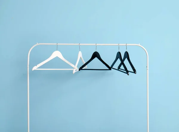Regal Mit Kleiderbügeln Aus Holz Auf Blauem Hintergrund — Stockfoto