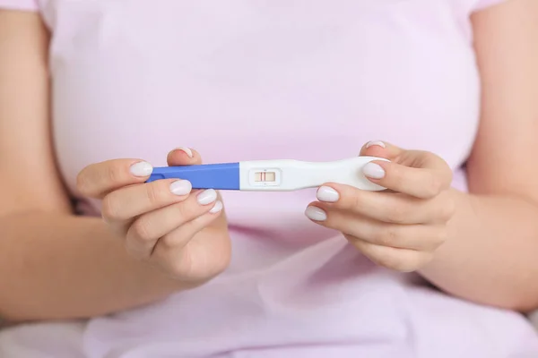 Young woman with positive pregnancy test, closeup