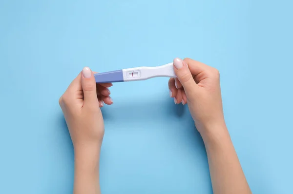 Weibliche Hände Mit Negativem Schwangerschaftstest Auf Farbigem Hintergrund — Stockfoto