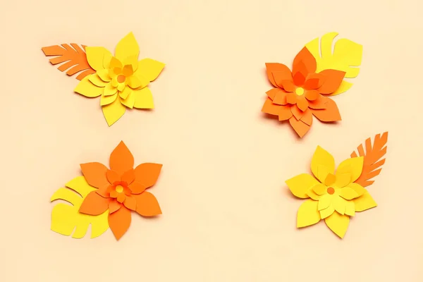 Colorful origami flowers with leaves on beige background