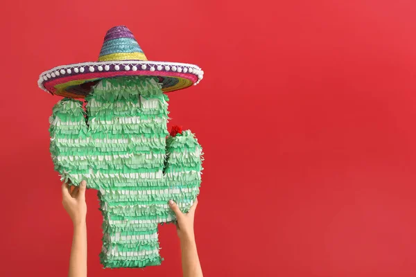 Manos Femeninas Sosteniendo Piñata Forma Cactus Sombrero Sobre Fondo Rojo —  Fotos de Stock