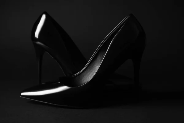 Stylish high heels on black background