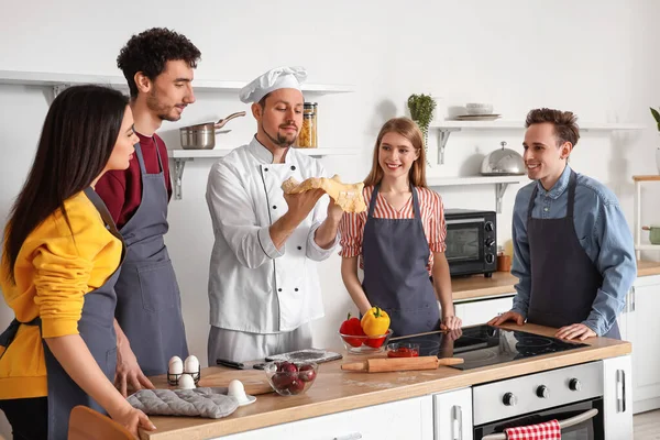 Włoski Kucharz Grupą Młodych Ludzi Przygotowujących Pizzę Podczas Lekcji Gotowania — Zdjęcie stockowe
