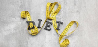 Measuring tape and word DIET on grey background, top view clipart